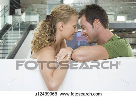 Young couple sitting on sofa View Large Photo Image Stock Photo - Young couple sitting on sofa. Fotosearch