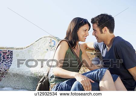 Young couple sitting on stone bench, portrait View Large Photo Image Picture - Young couple sitting on stone bench, portrait. Fotosearch