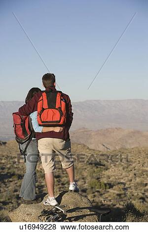 Stock Photo - Young couple stand looking at view. Fotosearch