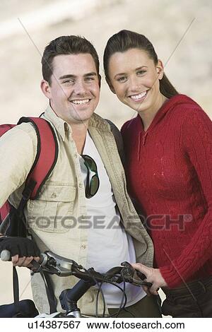 Young couple stand with mountain bike View Large Photo Image Stock Photo - Young couple stand with mountain bike. Fotosearch