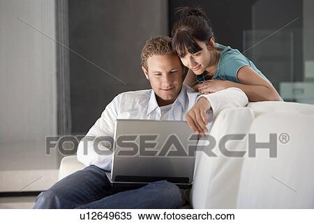 Young couple using laptop, portrait View Large Photo Image Stock Photography - Young couple using laptop, portrait. Fotosearch