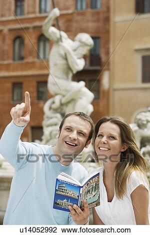 Young couple with guidebook looking at monuments on street in Rome, Italy, head and shoulders View Large Photo Image Stock Image - Young couple with guidebook looking at monuments on street in Rome, Italy, head and shoulders. Fotosearch