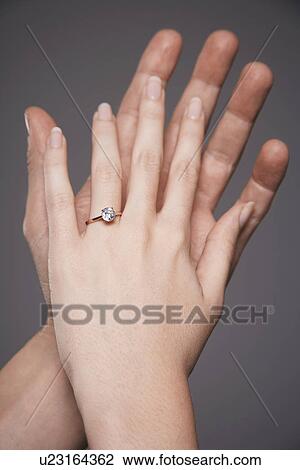 Young couple with hands raised together showing woman's engagement ring, close up on hands View Large Photo Image Stock Image - Young couple with hands raised together showing woman's engagement ring, close up on hands. Fotosearch