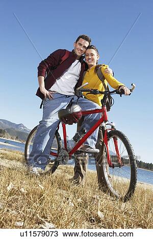 Young Couple with Mountain Bike, low angle view. View Large Photo Image Stock Image - Young Couple with Mountain Bike, low angle view.. Fotosearch