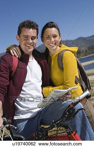 Stock Image - Young couple with mountain bike. Fotosearch