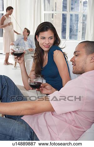 Young couples drinking wine in living room View Large Photo Image Stock Photo - Young couples drinking wine in living room. Fotosearch