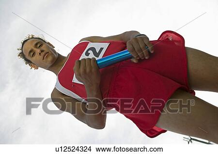 Young man holding relay baton, portrait View Large Photo Image Picture - Young man holding relay baton, portrait. Fotosearch