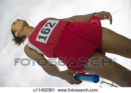 Young man holding relay baton View Large Photo Image Stock Image - Young man holding relay baton. Fotosearch