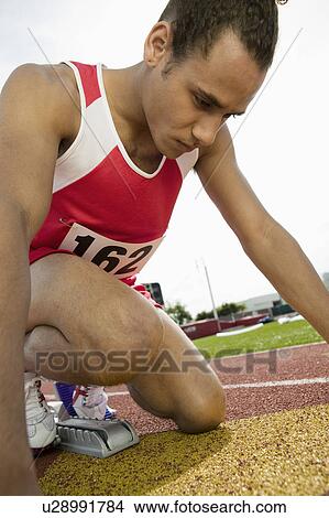 Young man in starting blocks View Large Photo Image Picture - Young man in starting blocks. Fotosearch