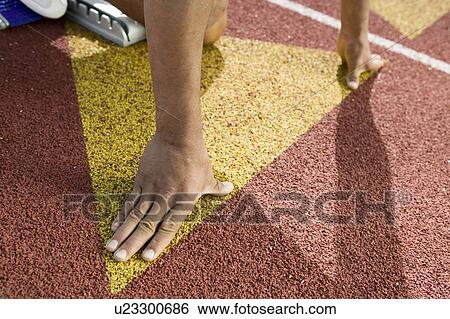 Young man in starting blocks View Large Photo Image Stock Photograph - Young man in starting blocks. Fotosearch