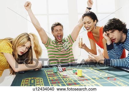 Young man winning on roulette table while friends lose View Large Photo Image Stock Image - Young man winning on roulette table while friends lose. Fotosearch