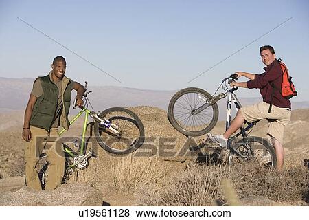 Young men stand with mountain bikes View Large Photo Image Stock Photo - Young men stand with mountain bikes. Fotosearch