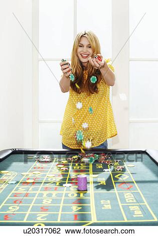Young woman celebrating with chips on roulette table View Large Photo Image Stock Image - Young woman celebrating with chips on roulette table. Fotosearch
