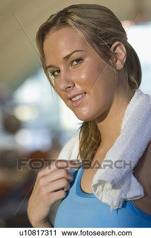Stock Image - Young Woman Holding Towel After Exercising. Fotosearch