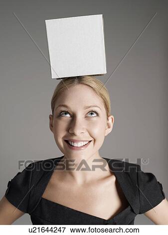 Young woman in black dress with white box on her head View Large Photo Image Stock Photo - Young woman in black dress with white box on her head. Fotosearch