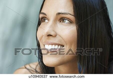 Stock Photo - Young woman in front of waterfall, close up of face. Fotosearch