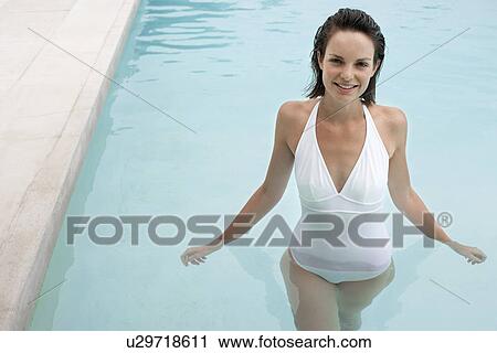 Stock Image - Young woman in swimming pool, portrait, elevated view. Fotosearch