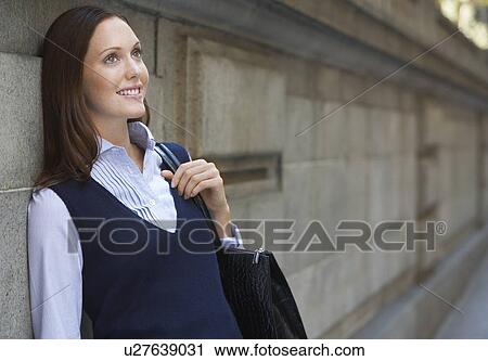Young woman leaning against wall in street View Large Photo Image Stock Image - Young woman leaning against wall in street. Fotosearch