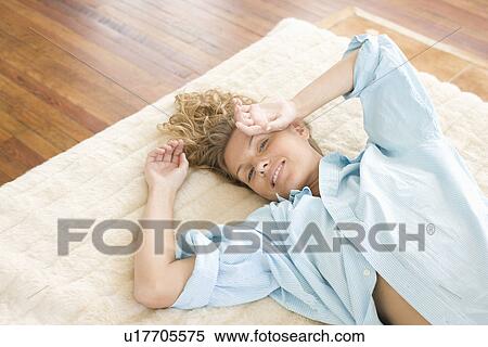 Young woman lying on bed View Large Photo Image Stock Photography - Young woman lying on bed. Fotosearch