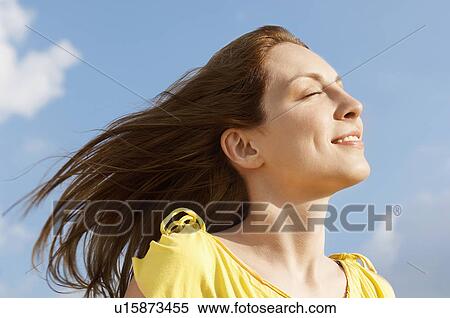 Young woman outdoors enjoying wind on face, close up View Large Photo Image Stock Photography - Young woman outdoors enjoying wind on face, close up. Fotosearch