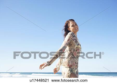 Stock Image - Young woman posing by sea, half-length. Fotosearch