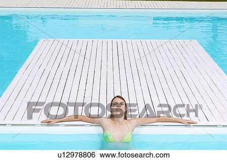 Young Woman relaxing in Swimming Pool, high angle view View Large Photo Image Stock Photograph - Young Woman relaxing in Swimming Pool, high angle view. Fotosearch