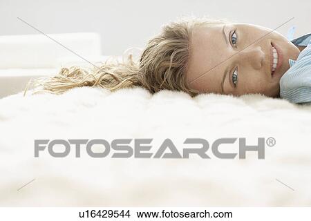 Young woman relaxing on bed, portrait View Large Photo Image Picture - Young woman relaxing on bed, portrait. Fotosearch