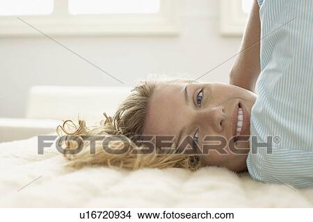 Young woman relaxing on bed, portrait View Large Photo Image Picture - Young woman relaxing on bed, portrait. Fotosearch