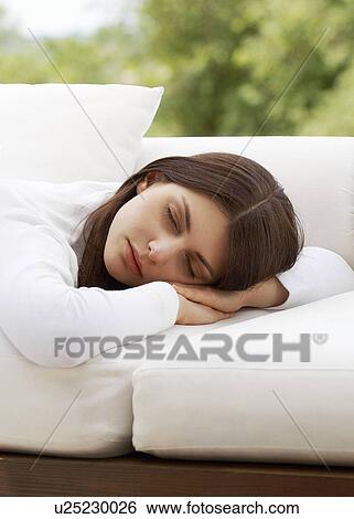 Stock Photograph - Young woman sleeping on sofa, portrait. Fotosearch