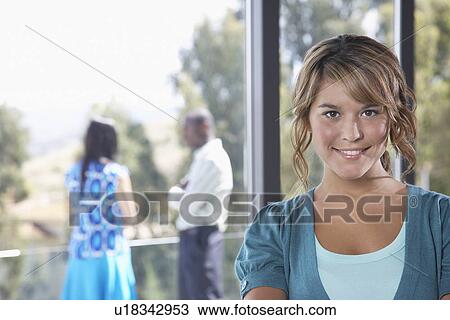 Stock Image - Young woman smiling indoors, portrait. Fotosearch