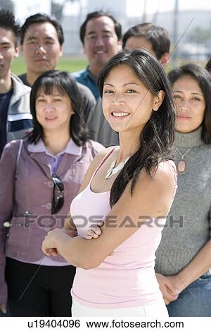 Stock Photograph - Young woman standing in crowd. Fotosearch