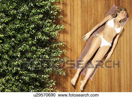 Stock Image - Young woman sunbathing in bikini, view from above. Fotosearch