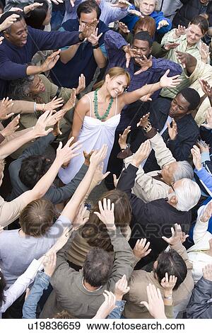 Stock Photo - Young woman surrounded by crowd. Fotosearch
