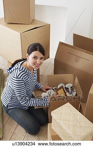 Picture - Young Woman Unpacking Boxes. Fotosearch