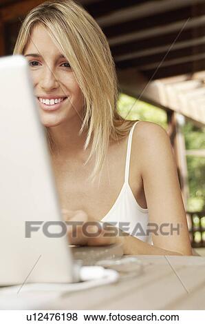 Stock Photo - Young woman using laptop, portrait. Fotosearch