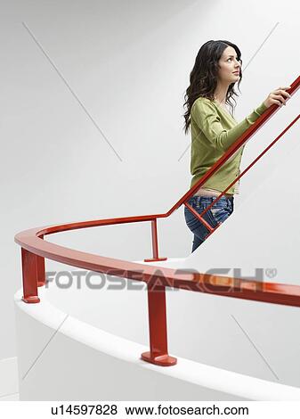 Young woman walking up stairs indoors View Large Photo Image Stock Photo - Young woman walking up stairs indoors. Fotosearch