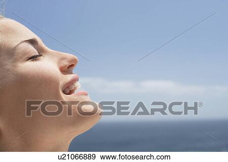 Young woman with eyes closed on beach, close-up View Large Photo Image Stock Photo - Young woman with eyes closed on beach, close-up. Fotosearch