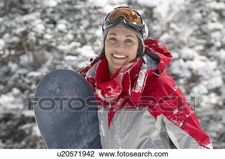 Stock Image - Young Woman with Snowboard in snow, half length. Fotosearch