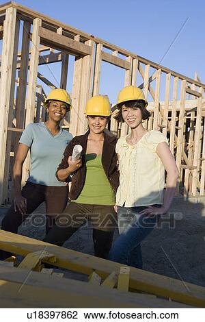 Stock Image - Young women in construction site. Fotosearch
