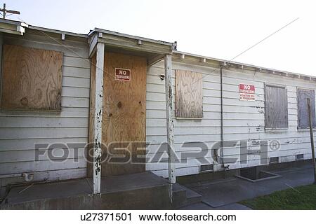 Stock Image - Abandoned Building With Boarded Windows and Peeling Paint. Fotosearch