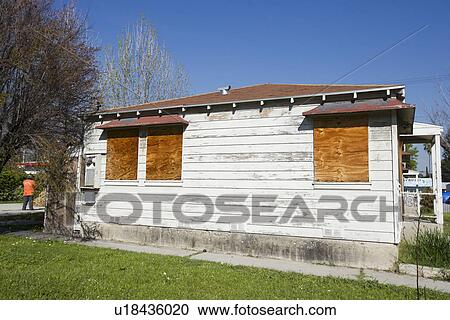 Stock Image - Abandoned House With Boarded Up Windows. Fotosearch