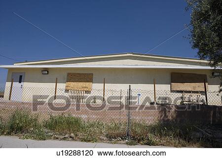 Stock Image - Abandoned House With Boarded Up Windows. Fotosearch
