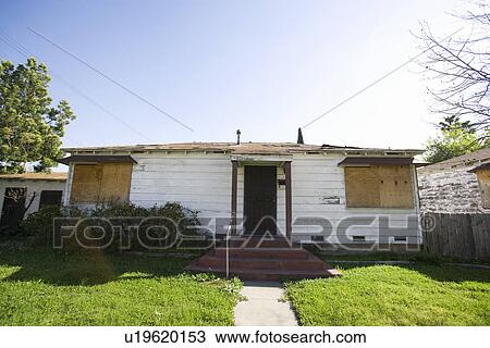 Stock Image - Abandoned House With Boarded Up Windows. Fotosearch