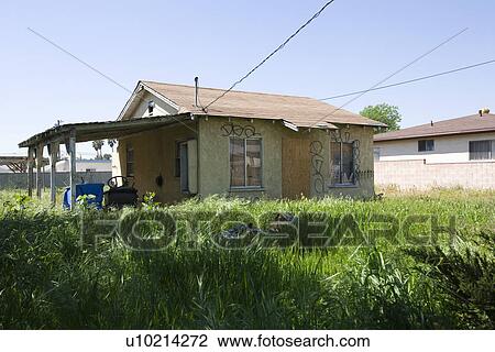 Stock Image - Abandoned House With Overgrown Yard. Fotosearch