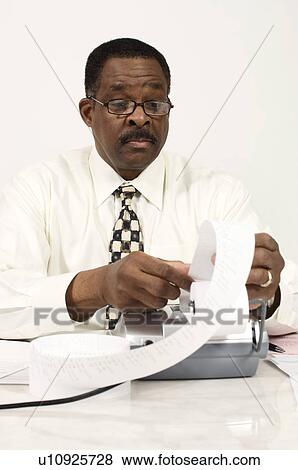 Stock Photo - Accountant Reading an Adding Machine Tape. Fotosearch