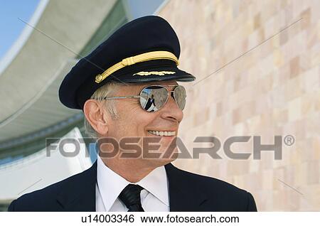 Stock Photograph - Airline pilot outside building, portrait, close up. Fotosearch