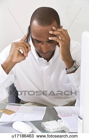 Stock Image - Anxious Man Doing Finances. Fotosearch