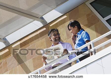 Stock Photo - Architect Holding Book with Building Plans. Fotosearch