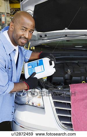 Auto Mechanic Adding Fluids to Minivan View Large Photo Image Stock Photo - Auto Mechanic Adding Fluids to Minivan. Fotosearch