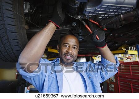 Auto Mechanic Beneath a Car View Large Photo Image Stock Photo - Auto Mechanic Beneath a Car. Fotosearch